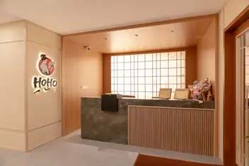 HOHO Nuru Massage: reception desk with wood panelling and Hoho logo