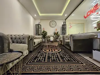 The One Massage Pattaya: reception lounge with grey sofas and a patterned rug